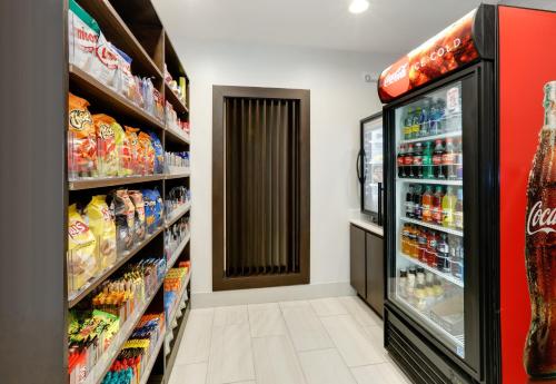 a grocery store aisle with a soda refrigerator at Holiday Inn Express & Suites Dallas NW - Farmers Branch by IHG in Farmers Branch