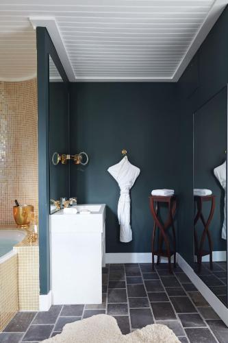 a bathroom with blue walls and a sink and stool at Grand Hotel Soleil d'Or in Megève