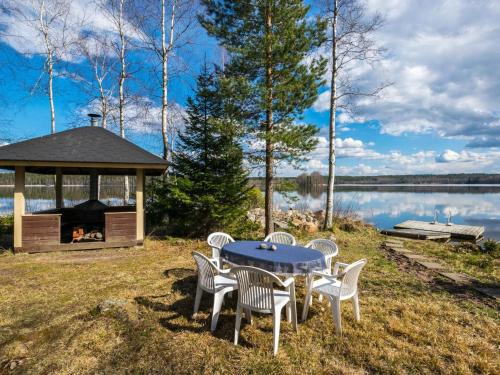 una mesa y sillas con un cenador junto a un lago en Holiday Home Lammassaari by Interhome, en Somerniemi
