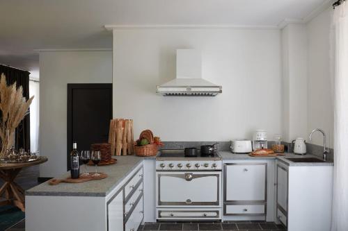 a white kitchen with a stove and a sink at Grand Hotel Soleil d'Or in Megève