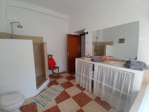 łazienka z umywalką, toaletą i lustrem w obiekcie Casa Alta Holiday Home w mieście El Esparragal