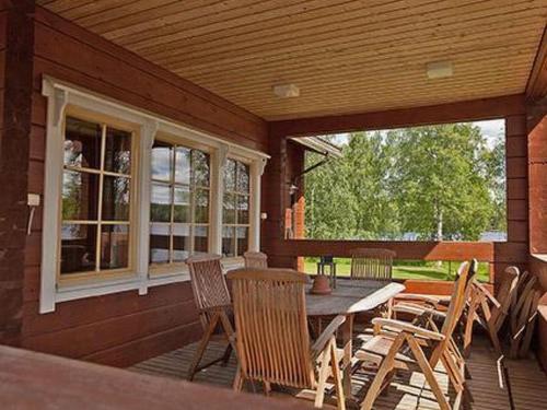 um pátio com uma mesa e cadeiras num alpendre em Holiday Home Koivuranta by Interhome em Sipsiö