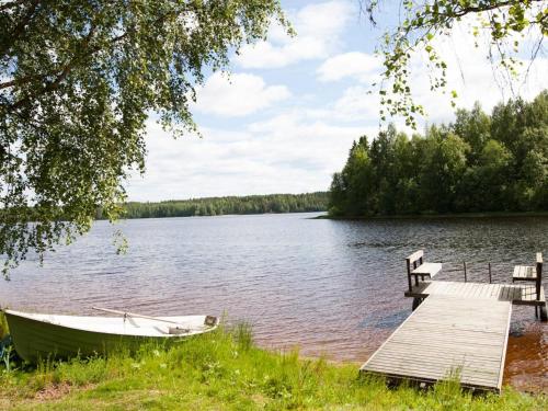 um barco na margem de um lago com uma doca em Holiday Home Koivuranta by Interhome em Sipsiö