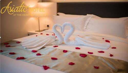 Ένα ή περισσότερα κρεβάτια σε δωμάτιο στο Asiatic Hotel