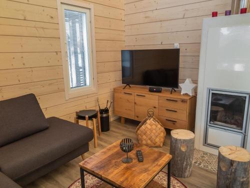 ein Wohnzimmer mit Sofa und Fernseher in der Unterkunft Holiday Home Äkäsmartti a by Interhome in Äkäslompolo