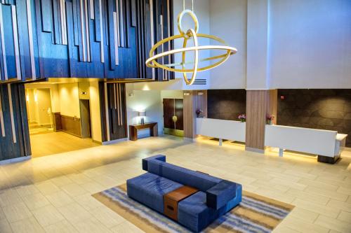 a living room with a blue couch and a chandelier at Crowne Plaza Dulles Airport by IHG in Herndon