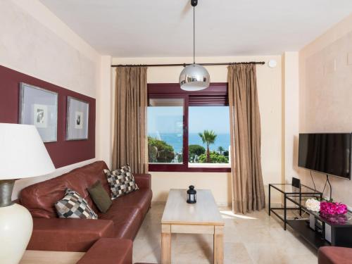 ein Wohnzimmer mit einem braunen Ledersofa und einem Fenster in der Unterkunft Apartment Vista Bahia by Interhome in Bahia de Casares