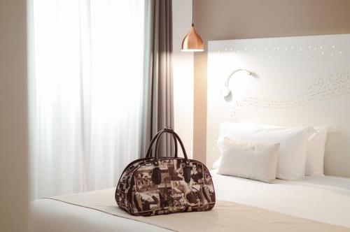 una mochila sentada en una cama en un dormitorio en The Walt Madrid, en Madrid