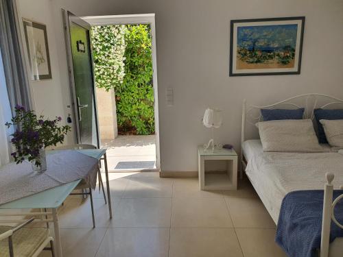 a bedroom with a bed and a table and a door at Apartmani Val in Pula