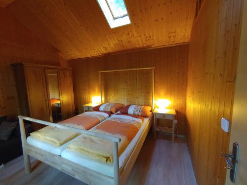 ヴェンディッシュ・リーツにあるFerienhaus Eschenalleeの木製の壁にベッド2台が備わるベッドルーム1室