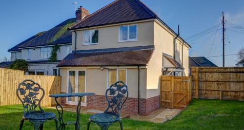 a house with a table and two chairs in the yard at Didcot- Private Flat with Garden & Parking 03 in Didcot