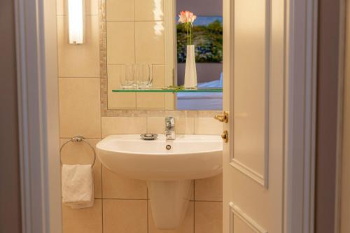 a bathroom with a sink and a mirror at Strandhotel Fontana in Timmendorfer Strand