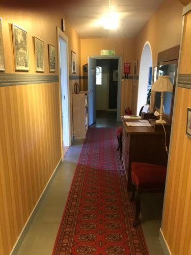 a hallway with a red rug on the floor at Rytterne Kyrkskola in Sorby