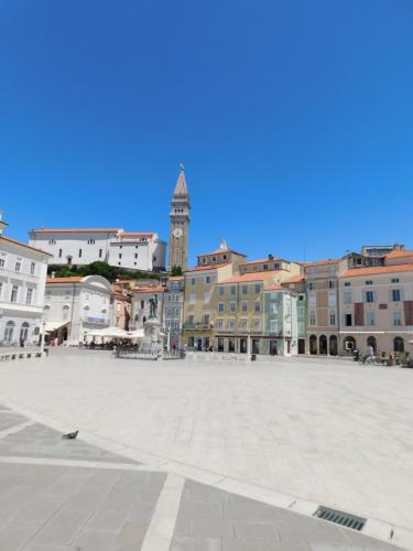 a city square with a clock tower in the background at Free Terrace in Piran