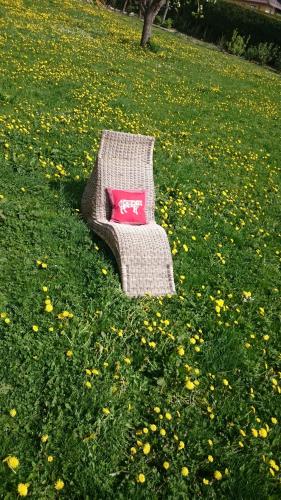 a couch with a pink pillow sitting in a field of flowers at Neubauerhof in Liebenfels