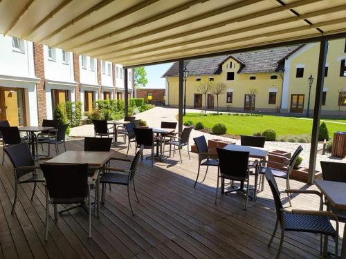 a patio area with tables, chairs and umbrellas at Statek 1738 in Všestudy