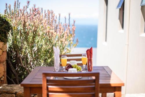a wooden table with glasses of orange juice on it at Simon’s Town Guest House in Simonʼs Town