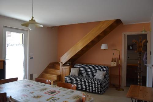 a living room with a table and a chair and a staircase at Casa Vecchia, ma Moderna in Villar Perosa