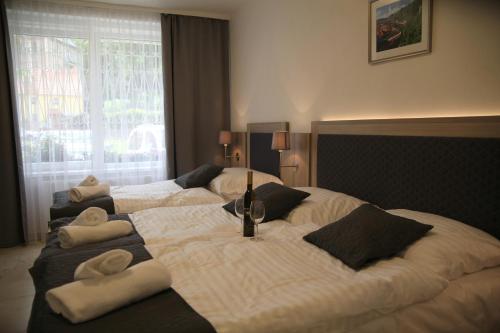 Dos camas en una habitación de hotel con toallas. en Hotel CK Park en Český Krumlov