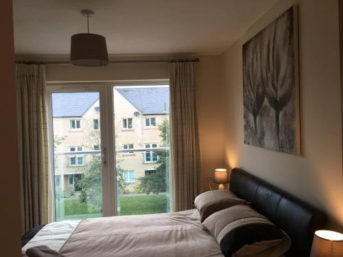 a bedroom with a bed and a large window at Penthouse Apartment On The River - 65 Skipper Way in Saint Neots