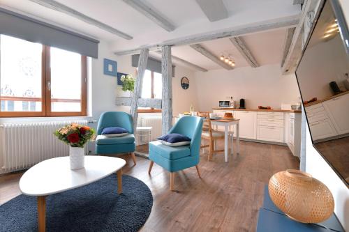 un salon avec des chaises bleues et une table dans l'établissement Appartement L'Authentique de la Petite Venise, à Colmar