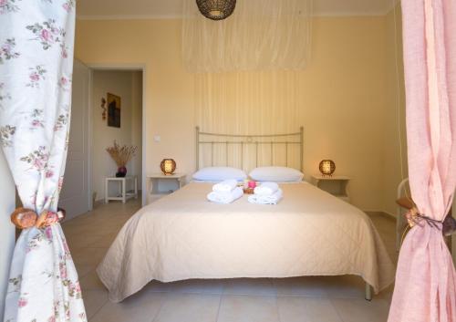 a bedroom with a bed with two towels on it at Avelia Pink in Asprogerakata