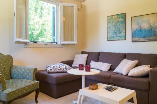 uma sala de estar com um sofá e uma mesa em Avelia Pink em Asprogerakata