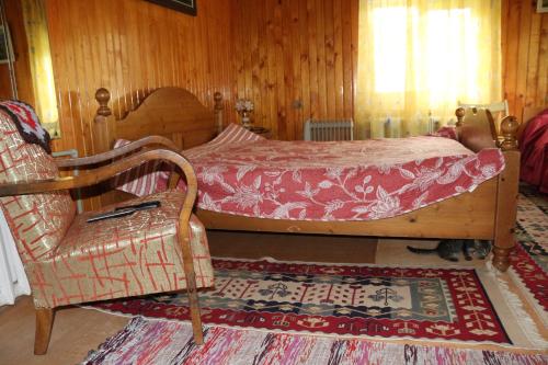 a bedroom with a bed and a chair and a rug at Sadyba Lukacha in Zhdenievo
