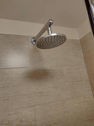 a shower head in a bathroom with a tile floor at 3 BR Ensuite Cottage Private Garden Parking Near St Neots in Saint Neots