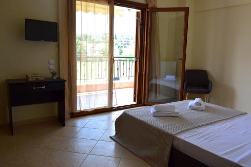 a bedroom with a bed and a sliding glass door at Bouganvillia Olivielias.Air2 in Néon Rýsion