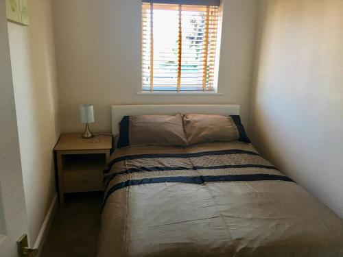 a small bedroom with a bed and a window at Eaton Ford Green Apartment in Saint Neots