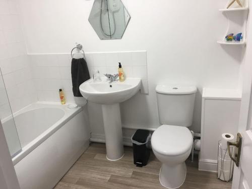 a white bathroom with a sink and a toilet at Eaton Ford Green Apartment in Saint Neots