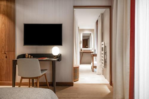 a bedroom with a desk and a television in a room at Coeur de Megève in Megève