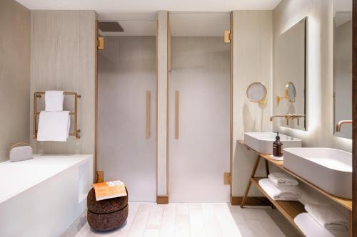 a bathroom with a tub and a sink and a shower at Coeur de Megève in Megève
