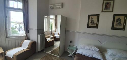 a bedroom with a mirror and a bed and a chair at Butterfly Home Danube in Budapest