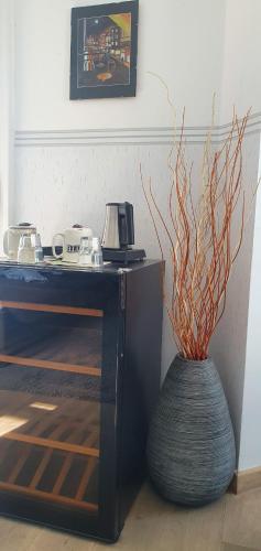 a vase with a plant in it next to a table at Butterfly Home Danube in Budapest