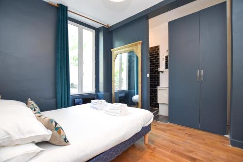- une chambre avec des murs bleus et un lit avec des draps blancs dans l'établissement Cosy apartment - 1BR-4P - Place de la Bastille, à Paris