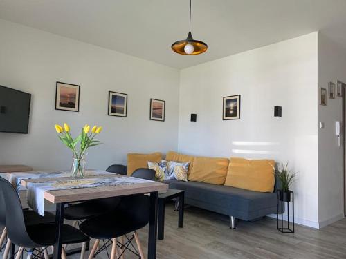 a living room with a couch and a table at Apartament SŁONECZNY Pięć mórz Sianożęty in Sianozety