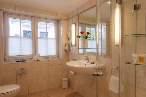 a bathroom with a sink and a toilet and a shower at Strandhotel Fontana in Timmendorfer Strand