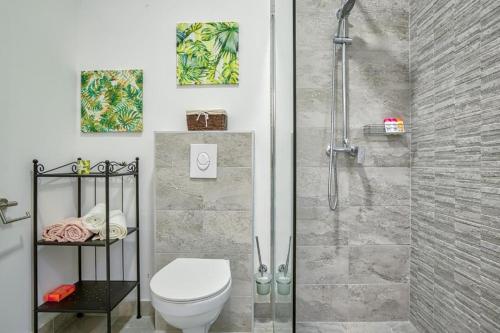 uma casa de banho com um chuveiro e um WC. em Amphitheater Garden Studio Apartments em Pula