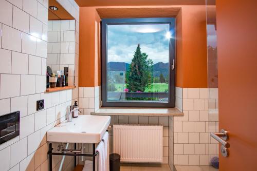 a bathroom with a sink and a window with a christmas tree at Hotel Bussi Baby in Bad Wiessee