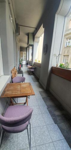 a hallway with a table and chairs and windows at Butterfly Home Danube in Budapest