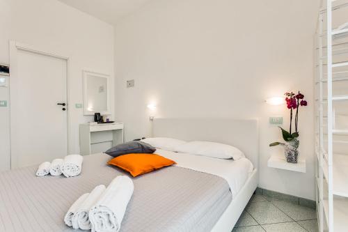 a white bedroom with a bed with towels on it at Mare Home Brunch&Beauty - Adults Only in Cesenatico