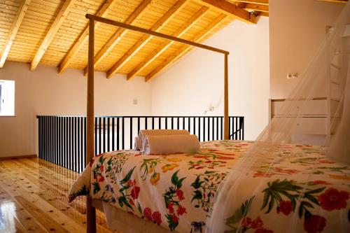 una camera con un letto in una stanza con pavimenti in legno di Quinta David ad Alvor