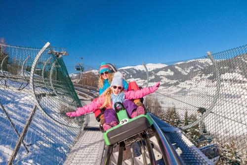 two girls on a ski lift in the snow at Pension Patricia - Summercard included from may 15th in Kaprun