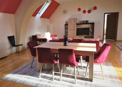 a dining room with a table and red chairs at Rozsi Mama in Sovata