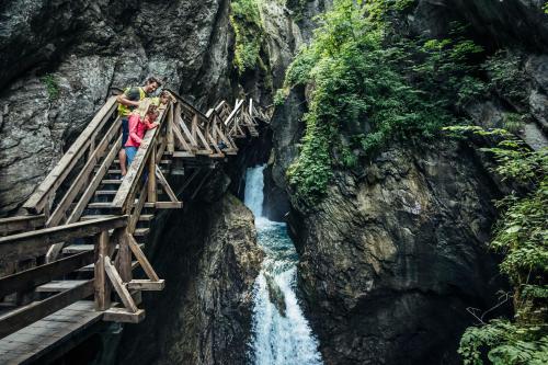 two people standing on a wooden bridge over a waterfall at Pension Patricia - Summercard included from may 15th in Kaprun