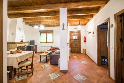 un soggiorno con un tavolo e un divano di Casa Rural LAS ABUBILLAS a Mirabueno