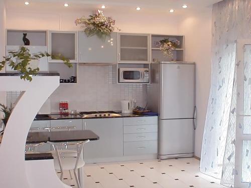 a kitchen with white appliances and a table and a refrigerator at Ok Apartments near Palace Sporta - Kiev in Kyiv