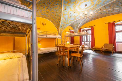 a room with a dining table and bunk beds at Burg Hostel Sighisoara in Sighişoara
